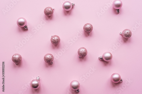 Scattered Christmas balls on a pink background, New Year concept. Top view, flat lay.