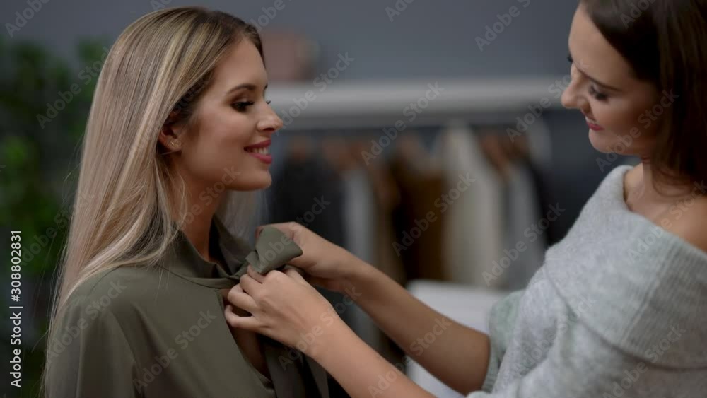 Shop assistant helping customer in clothes shop Shop assistant helping customer in clothes shop