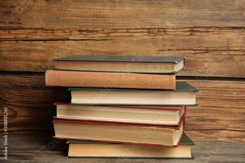 Collection of different books on table against wooden background