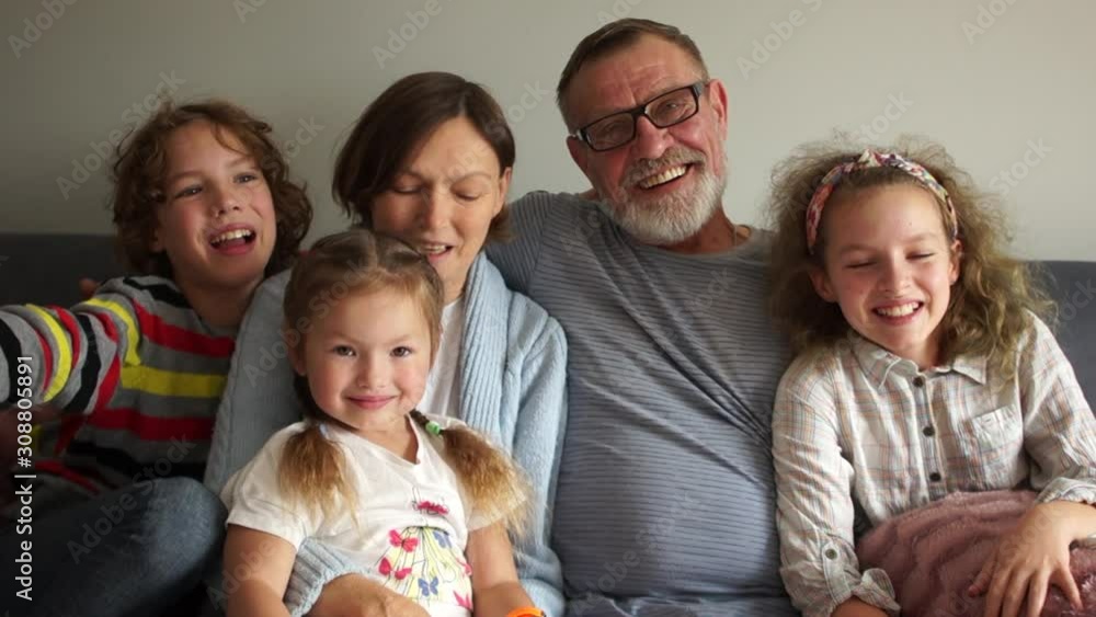 Lovely big happy family. Portrait of grandparents with three grandchildren. A large group of people, five people are sitting on the couch and posing for a photo Lovely big happy family. Portrait of grandparents with three grandchildren. A large group of people, five people are sitting on the couch and posing for a photo