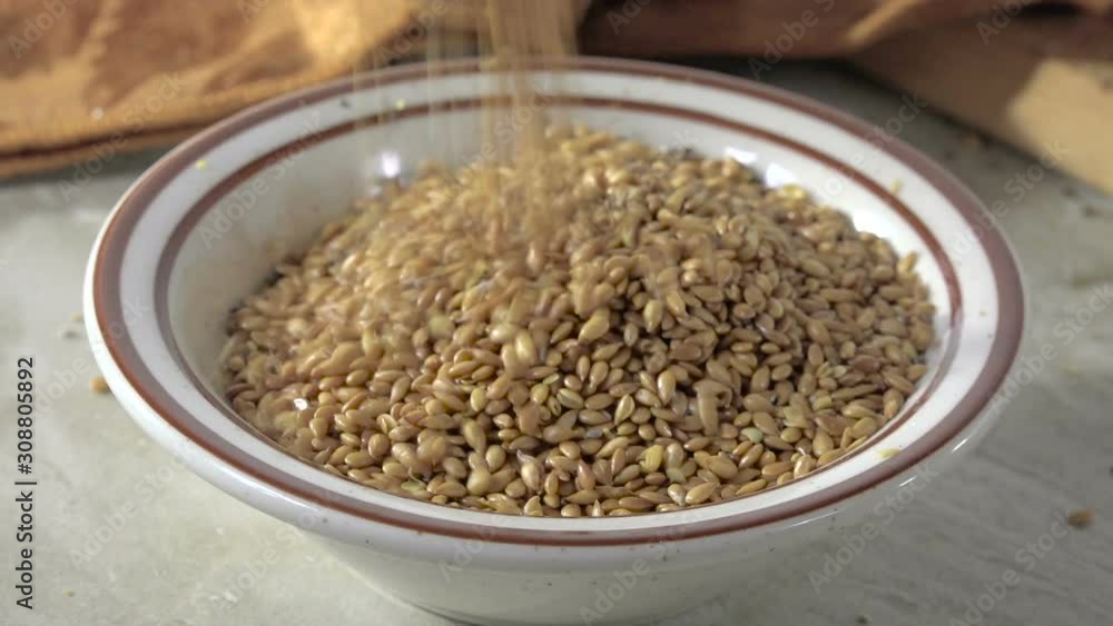 Pouring roasted flax seed into a small bowl Pouring roasted flax seed into a small bowl