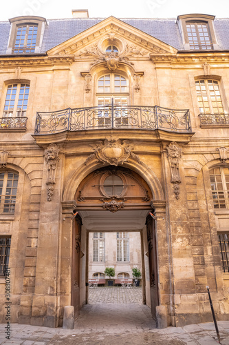 Paris, beautiful wooden door, typical window and balcony in the Marais, with carved lintel