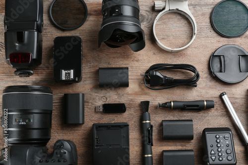 Flat lay composition with equipment for professional photographer on wooden table