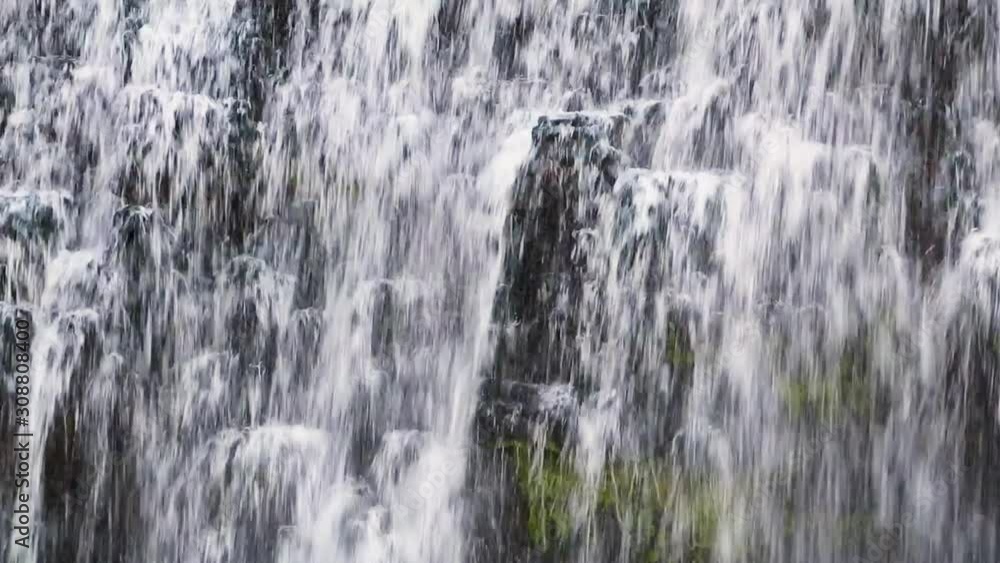 Water splashes and cascades down a beautiful waterfall flowing over a rock face in this seamless video loop Water splashes and cascades down a beautiful waterfall flowing over a rock face in this seamless video loop