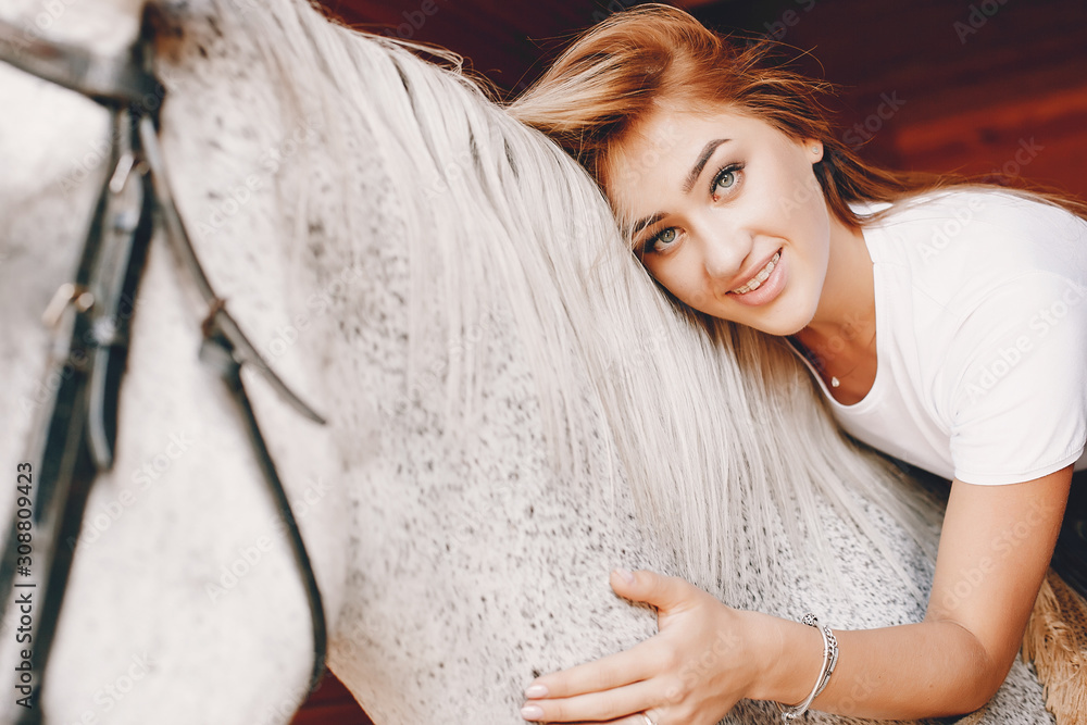 Cute girl with a horse. Lady in a white t-shirt. Woman in a summer park Cute girl with a horse. Lady in a white t-shirt. Woman in a summer park