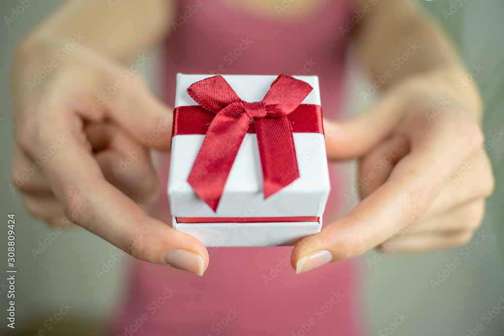 Girl with outstretched hands with a box in her hands isolated on a light background, copy space Girl with outstretched hands with a box in her hands isolated on a light background, copy space