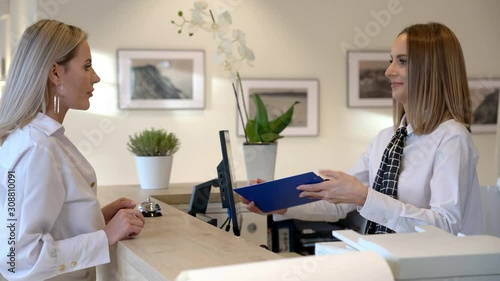 Receptionist assisting hotel guest at desk