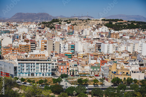 Fototapeta Naklejka Na Ścianę i Meble -  Beautiful wide aerial view of Alicante, Valencian Community, Spain with port of Alicante, beach and marina, with mountains and skyline, seen from Santa Barbara Castle on Mount Benacantil, sunny day