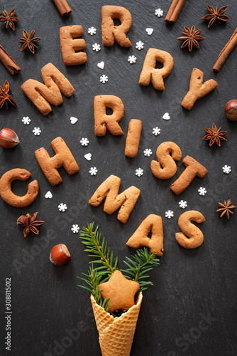 Gingerbread words Merry Christmas on dark stone background. Top view.