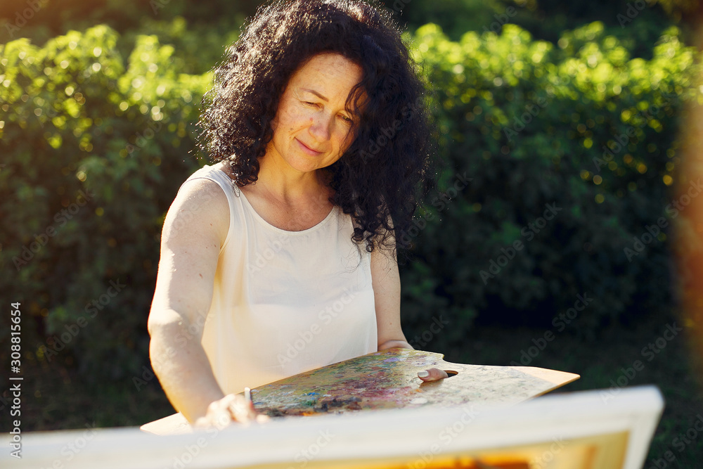 Woman artist painting with oil. Paints in a field Woman artist painting with oil. Paints in a field