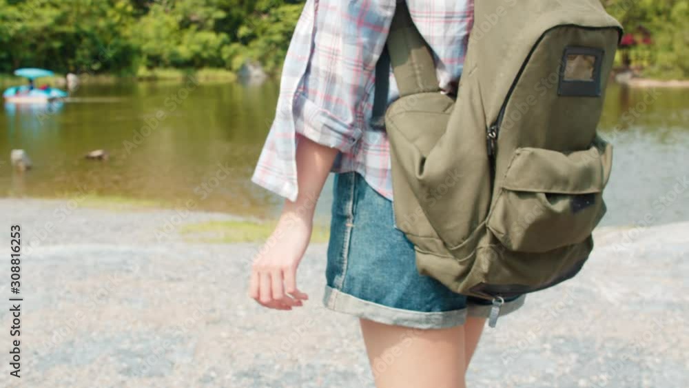 Cheerful young traveler Asian lady with backpack walking at the mountain lake. Korean teen girl enjoy her holidays adventure feeling happy freedom. Lifestyle travel and relax in free time concept. Cheerful young traveler Asian lady with backpack walking at the mountain lake. Korean teen girl enjoy her holidays adventure feeling happy freedom. Lifestyle travel and relax in free time concept.