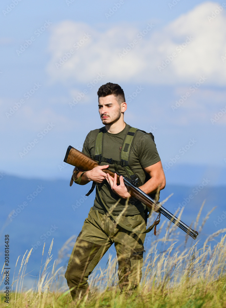 Fototapeta premium Guard the borders. Man with weapon military clothes in field nature background. Soldier with rifle. Army forces. State border guard service. Protecting borders of motherland. Stop illegal immigrants