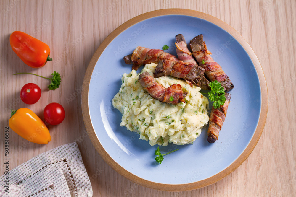 Lamb liver wrapped in bacon with mash potato. View from above, top Lamb liver wrapped in bacon with mash potato. View from above, top