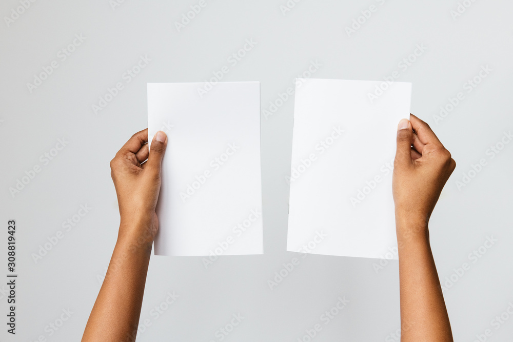 Studio shot of a woman of color holding an A5 or folded letter size blank mockup - obrazy, fototapety, plakaty 