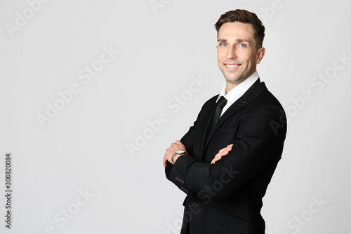 Handsome young businessman on grey background