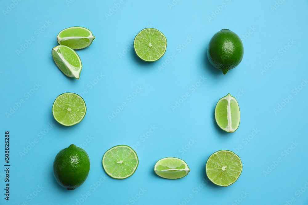 Flat lay composition with fresh juicy limes on light blue background. Space for text