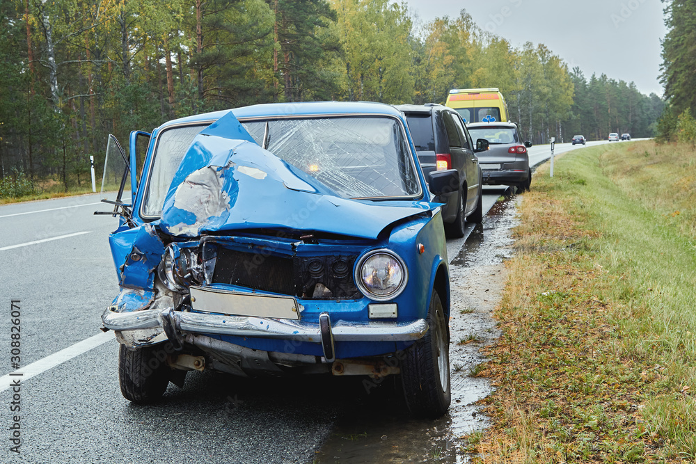 damaged old car on the highway at the scene of an accident