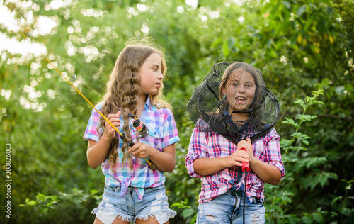 Happy smiling children with net and rod. Happy childhood. Adorable girls nature background. Teamwork. Camping activities. Fly fishing. Kids spend time together fishing. Fishing skills. Summer hobby