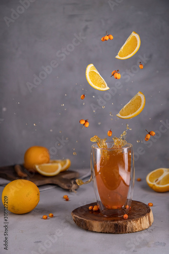  orange tea with sea buckthorn, warm on holidays, flying berries and citruses, drops of water