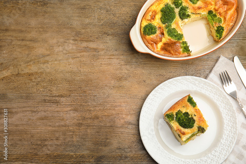 Tasty broccoli casserole served on wooden table, flat lay. Space for text