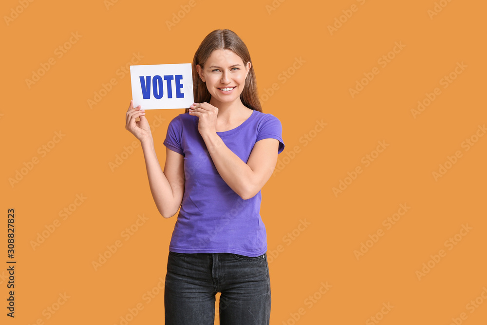 Young woman holding paper with text VOTE on color background Young woman holding paper with text VOTE on color background
