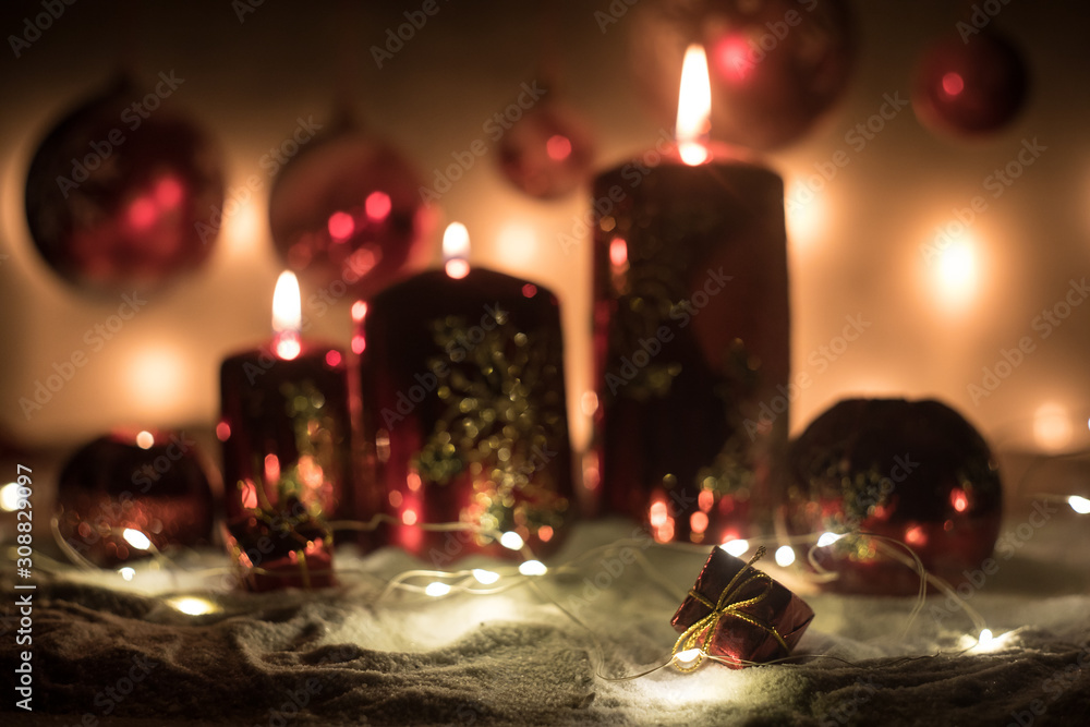 Creative artwork decoration. Christmas decoration with burning candles on a dark background. Christmas ornaments over dark golden background with lights. Creative artwork decoration. Christmas decoration with burning candles on a dark background. Christmas ornaments over dark golden background with lights.