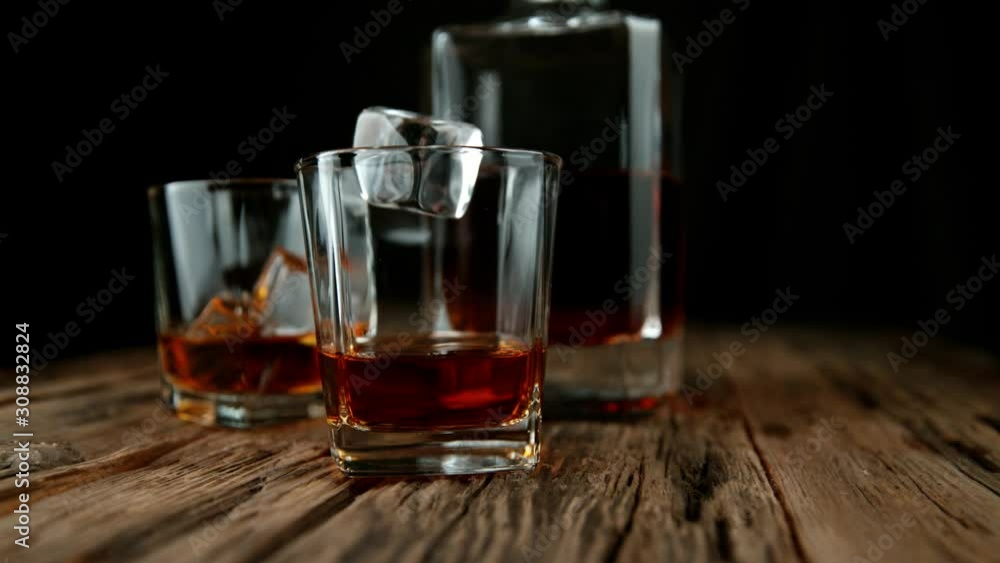 Super slow motion of falling ice cube into whiskey drink. Filmed on high speed cinema camera, 1000 fps. Super slow motion of falling ice cube into whiskey drink. Filmed on high speed cinema camera, 1000 fps.