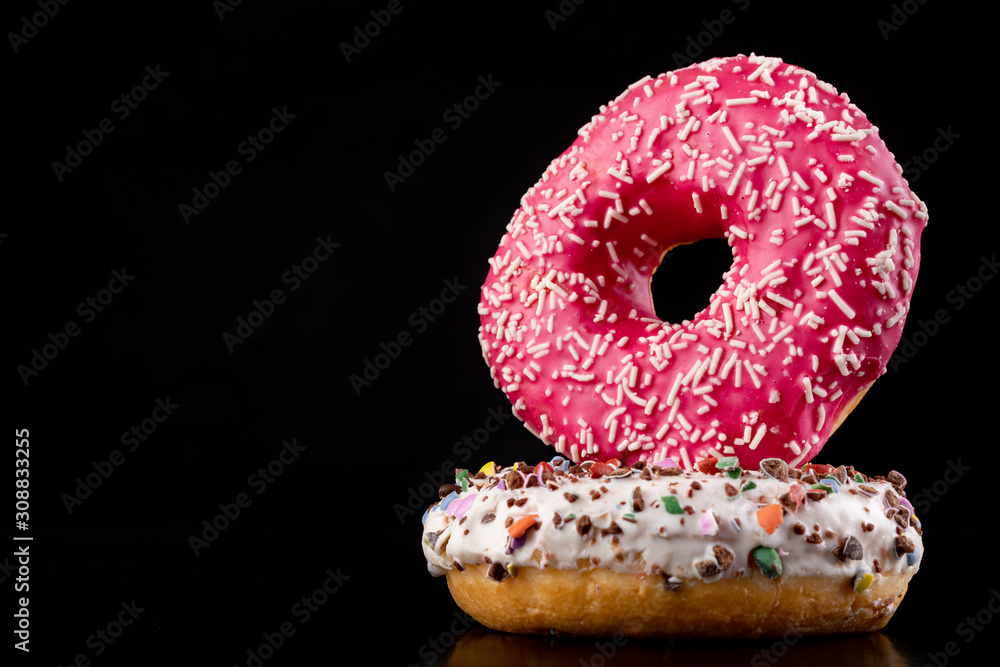 Donut on a dark kitchen table. A delicious sweet dessert decorated with sprinkles. Donut on a dark kitchen table. A delicious sweet dessert decorated with sprinkles.