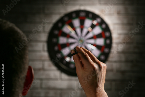 Young man playing darts indoors photo