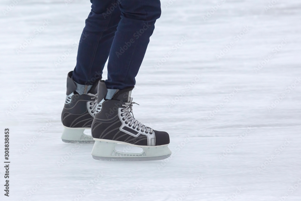 feet on the skates of a person rolling on the ice rink. Hobbies and sports. Vacations and winter activities. feet on the skates of a person rolling on the ice rink. Hobbies and sports. Vacations and winter activities.