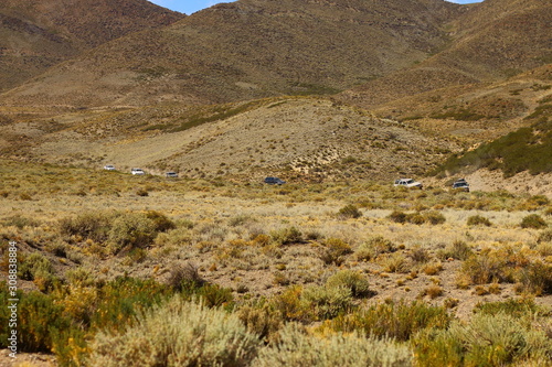 camionetas vistas a lo lejos en camino demontaña