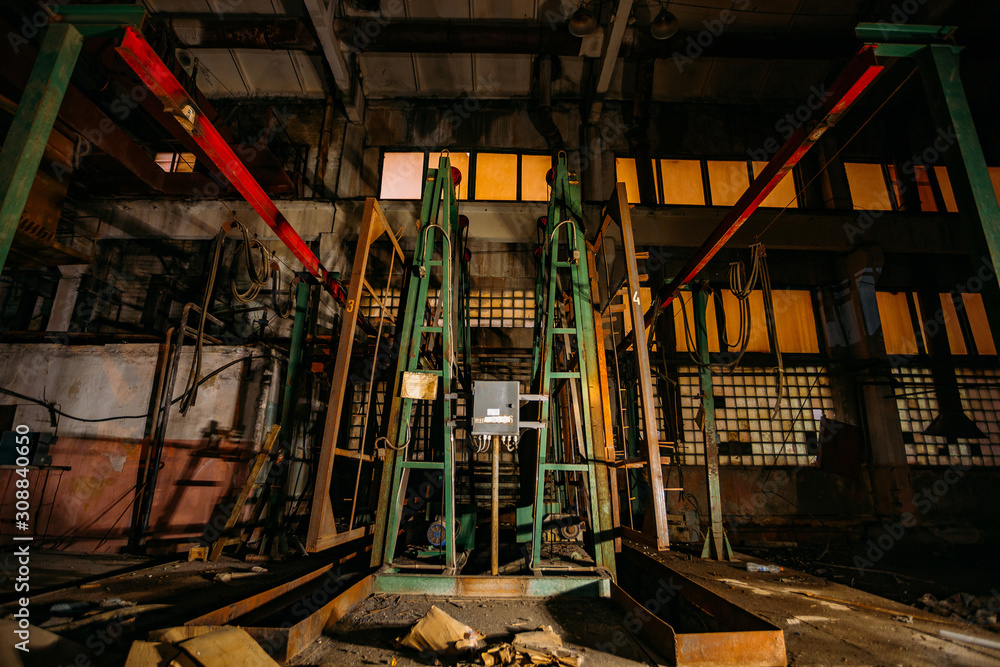 Abandoned concrete factory at night. Old rusty machinery