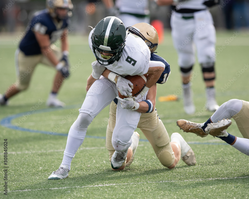 Action photo of athletic football player making amazing play during a football game Action photo of athletic football player making amazing play during a football game