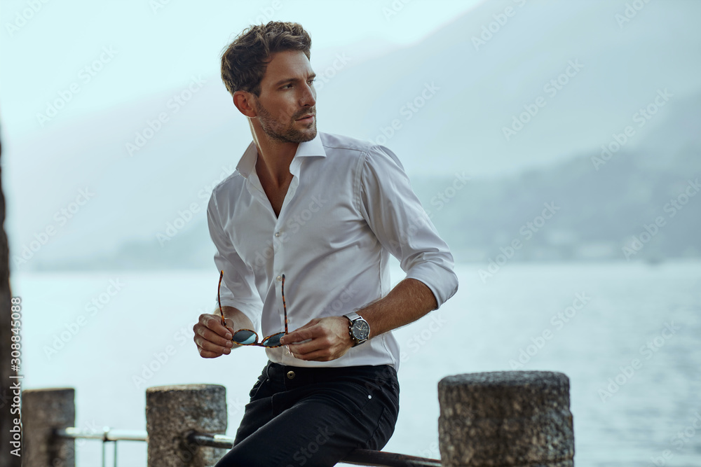 Stylish man in white classic shirt, looking at the mountains view - obrazy, fototapety, plakaty 