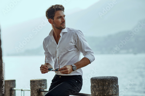 Stylish man in white classic shirt, looking at the mountains view photo