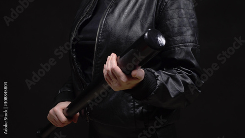 closeup. female hands holding a baseball bat on black background © kopitinphoto