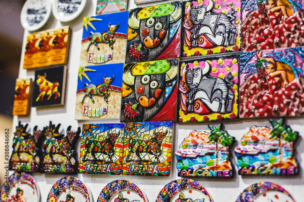 View of traditional tourist souvenirs and gifts from Spain, Alicante, Valencia with toys, bull figures, flamenco dancer dolls, fridge magnets with and key ring keychain, in local vendor souvenir shop View of traditional tourist souvenirs and gifts from Spain, Alicante, Valencia with toys, bull figures, flamenco dancer dolls, fridge magnets with and key ring keychain, in local vendor souvenir shop