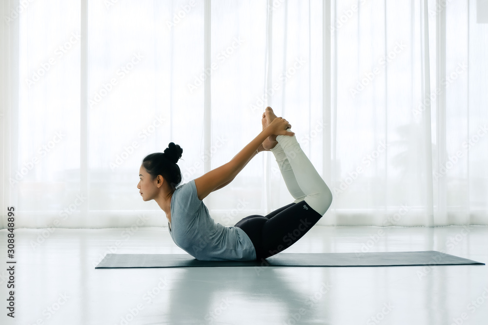 Premium Photo | Woman practicing yoga doing dhanurasana exercise with straps  bow pose exercising in sportswear lying