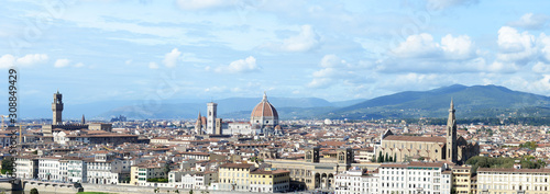 Panoramic view over Florence on a cloudy October day with cathedral, palazzo vecchio, giotto's bell tower, and other landmarks, with Tuscan hills in the back, as seen from Piazzale Michelangelo