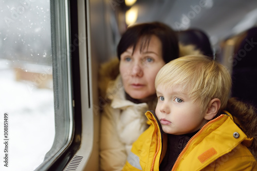 Family looking out of the window of train during travel on cogwheel railway/rack railway in Alps mountains. © Maria Sbytova