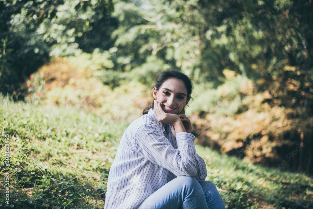 Confidence woman sitting and looking something at public park in the morning,Happy and smiling,Relaxing time,Positive thinking