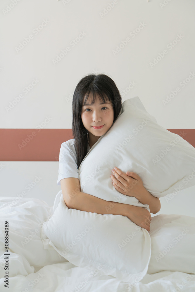 young woman holding pillow on the bed at home young woman holding pillow on the bed at home