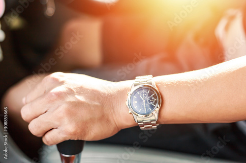 hand wear a watch and catch car gear.