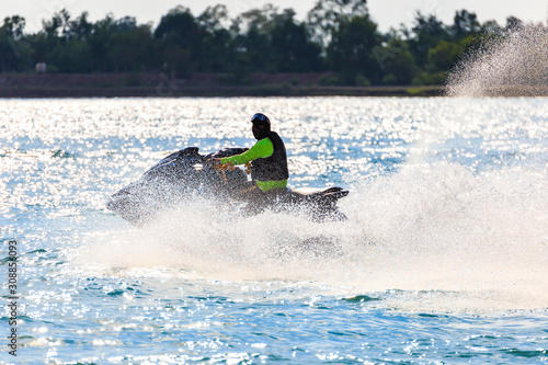 A man ride jet ski in the river with water splash.