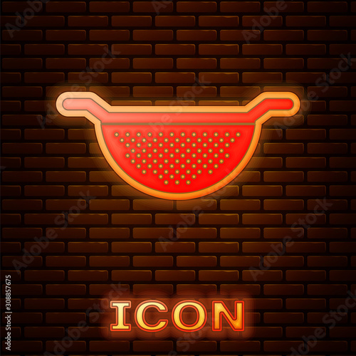 Glowing neon Kitchen colander icon isolated on brick wall background. Cooking utensil. Cutlery sign. Vector Illustration