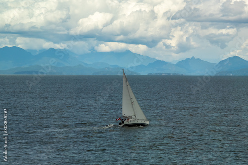 Solitude - sailboat at sea, mountains and clouds
