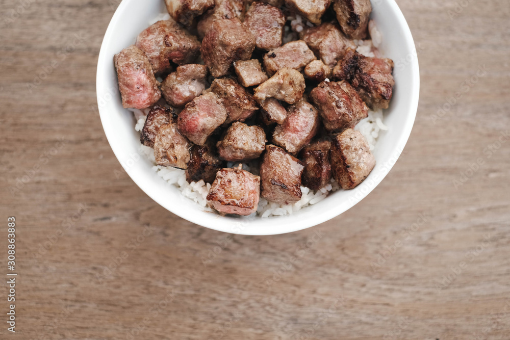 Homemade Bowl of Diced Beef Steak with rice Japanese style on wooden table. Homemade Bowl of Diced Beef Steak with rice Japanese style on wooden table.