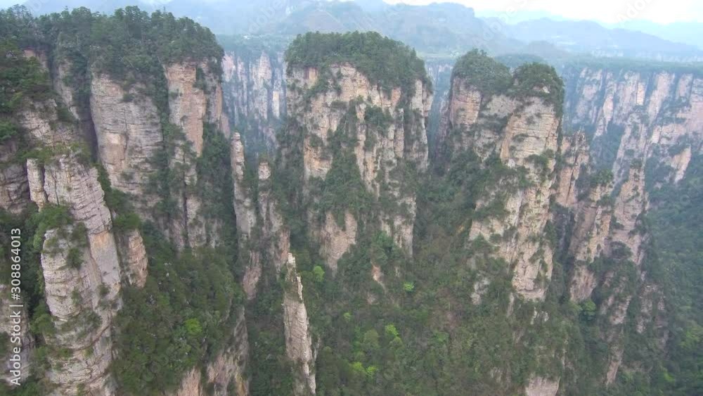 Drone footage of tall rock pillars (forest) and vegetation on them in ...