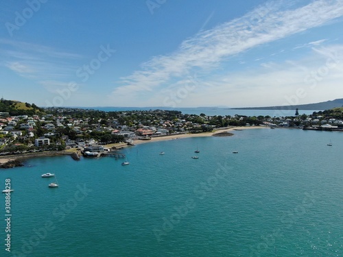 Devonport, Auckland / New Zealand - December 11, 2019: The Victorian Style Seaside Village of Devonport, with the skyline of Auckland’s landmarks and CBD in the background