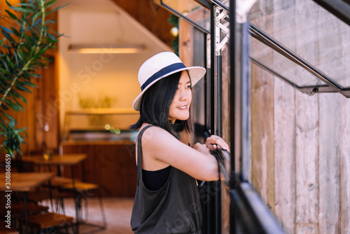 Happy asian woman standing and looking something on window at modern cafe,Happy and smiling,Relaxing time,Positive thinking